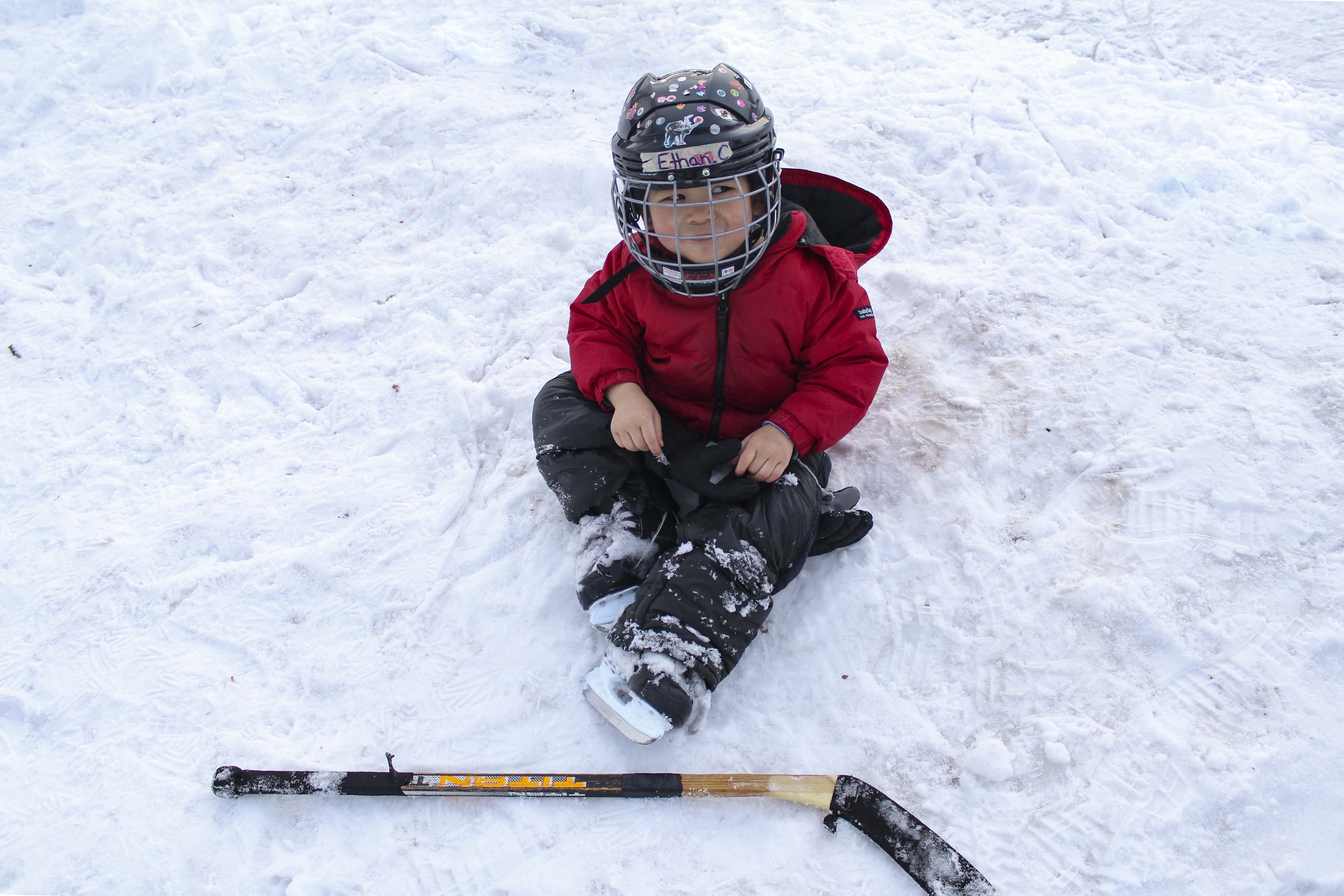 Ethan Chu, (age), rests on the âbenchâ of an intense hockey match by his brother and other friends by the Highland Park Community Centre in Calgary on Sunday, Jan. 31, 2021. The January weather has been pleasantly warm for the families to enjoy their weekend on community ice rinks. (Photo by Meng Wei/The Press)